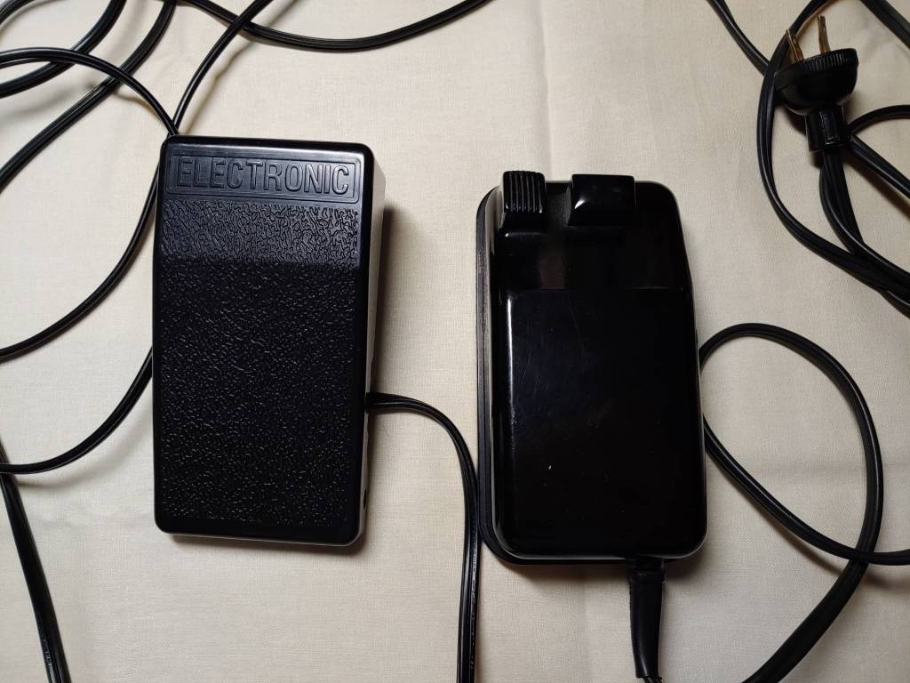 A plastic and a ceramic foot pedal sitting side by side