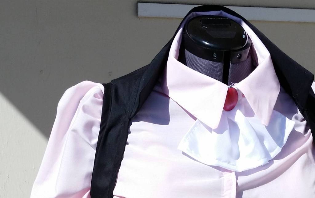 Cosplay showing several different pleats. The sleeve has pleats at the shoulder seam and the cravat has pleats to make it bell outward in a triangle shape.