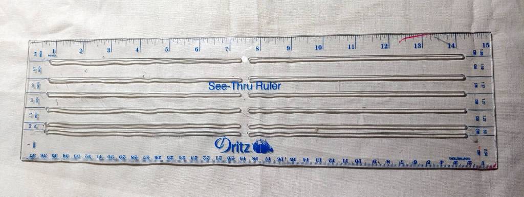 A clear hemming ruler. This ruler has cutouts with standard seam allowances