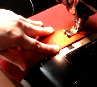 Gif showing how to sew a backstitch by straddling the machine foot