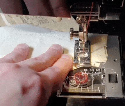 Gif showing how to end with a backstitch using an alternate hand position next to the foot instead of in front of it.
