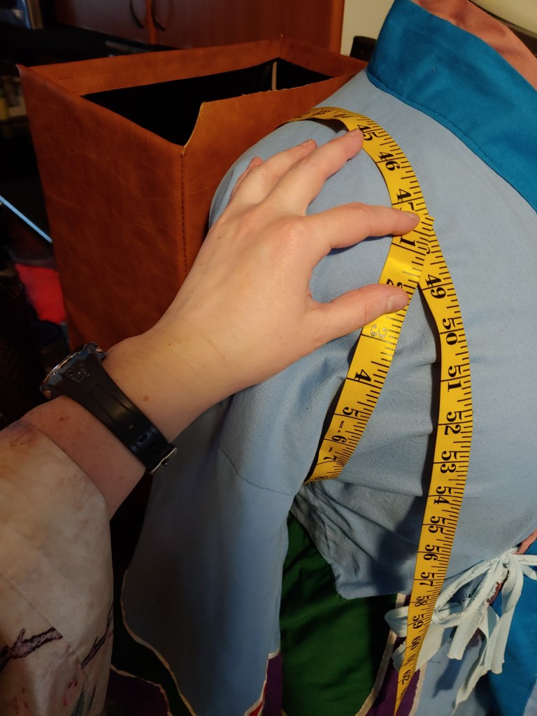 Wrapping the measuring tape around the shoulder after threading it through the backpack
