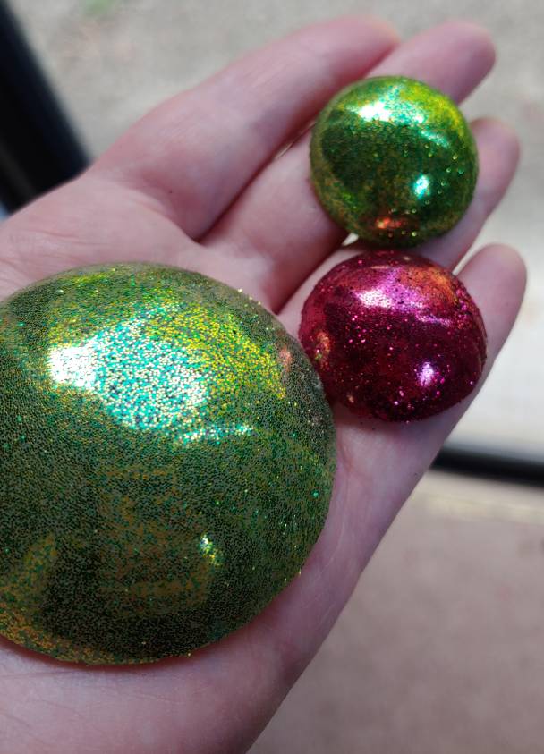 Various sizes of glitter glue gems in red and green