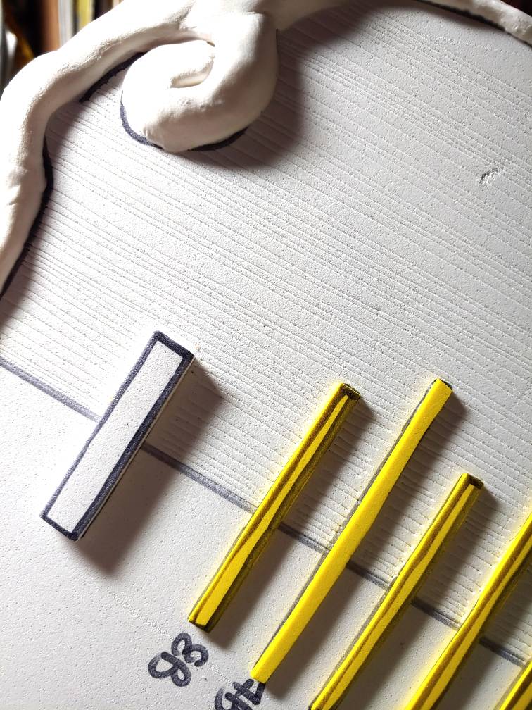 Carving wood grain. Only one half is carved, and the markings are somewhat irregular but also still parallel. This makes a more natural wood look.