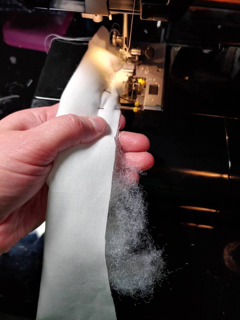 Sewing the noodles while stuffing them with fluff at the same time. It's definitely noodle stufffing