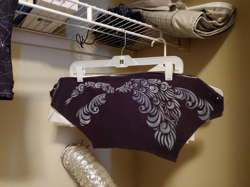Sections of a tunic hanging over my dryer on a pants hanger.