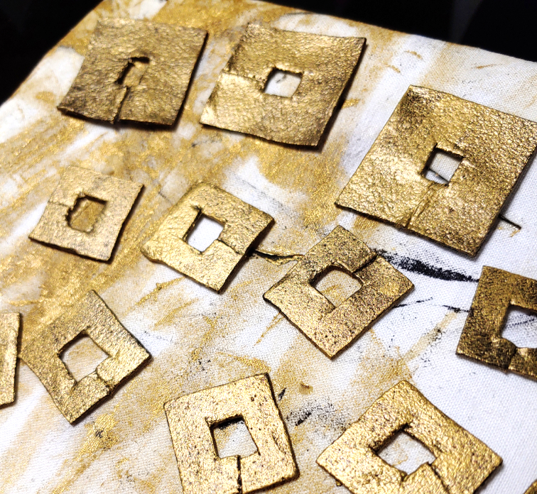 coins painted using a makeup wedge to give them a weathered metallic look