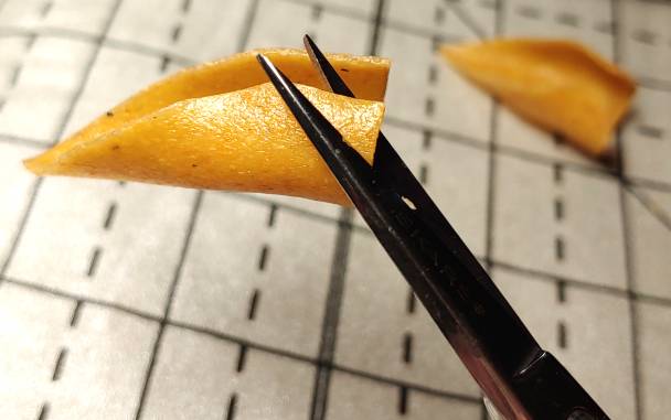 Trimming the sharp fingertip edge with a pair of also sharp embroidery scissors