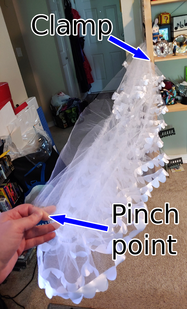 folding process, labeling the clamp and the pinch point. Clamp is attached to a bookshelf and holding the tier in place. Drawing backwards finds the pinch point.