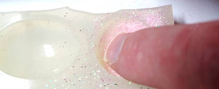 Using a finger to spread the glitter in the mold