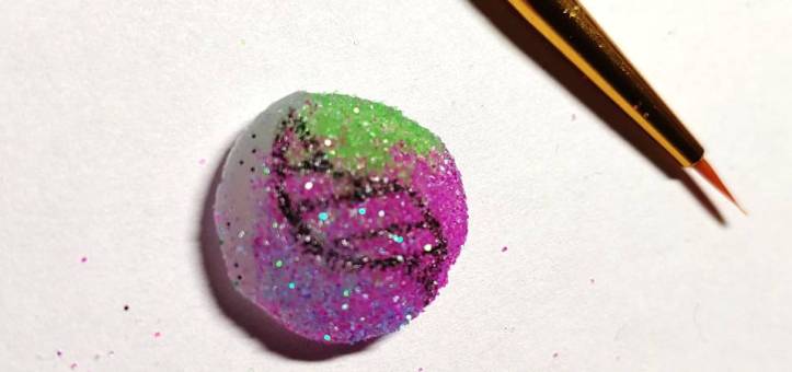 A mega evolution stone painted with a fine brush