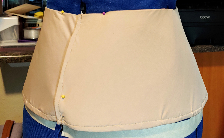 A completed basque, pinned to the dress form.