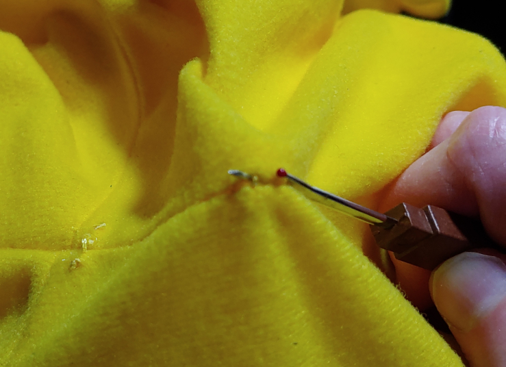 Ripping the back neck seam with a seam ripper.