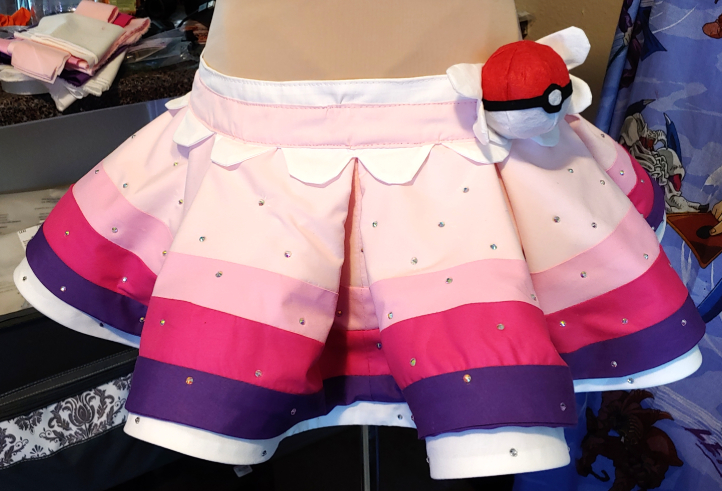 Skirt, sewn to the basque with finished embellishments.