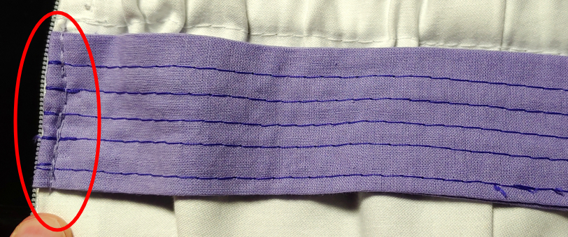 Back of the strap sewn next to the zipper.