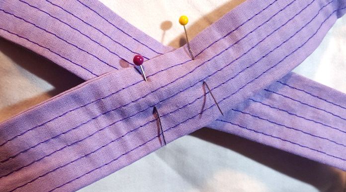 Straps crossed over each other then pinned together.