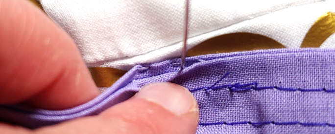 Straight stitches hidden inside the ironed edge.