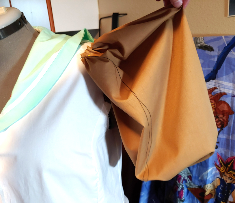 Testing the sleeve pattern by pinning it to the shirt on the dress form. Pull the sleeve out a bit to see how it looks puffed up.