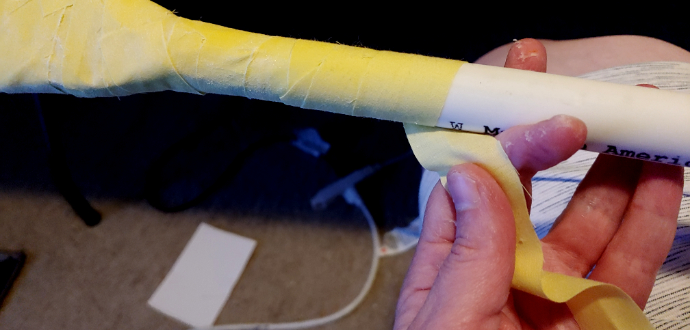 wrapping pale yellow fabric over a PVC pipe as the permanent base