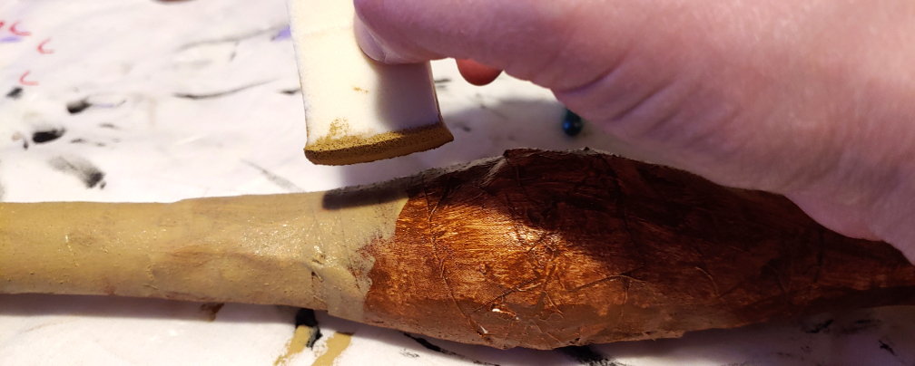 Chocolate brown painted onto the stick by dabbing a makeup sponge onto the surface