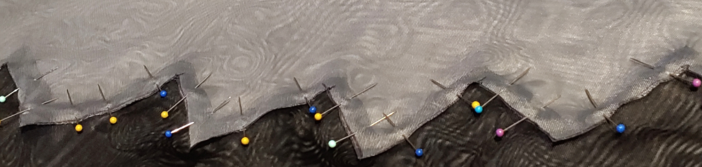 Black and gray tiers pinned together at the zigzags using tiny colorful stick pins