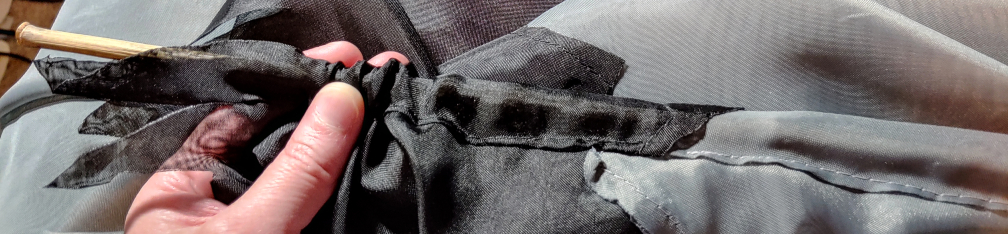 Feeding the bamboo stick into the casing. The fabric is partially scrunched to help guide the stick inside