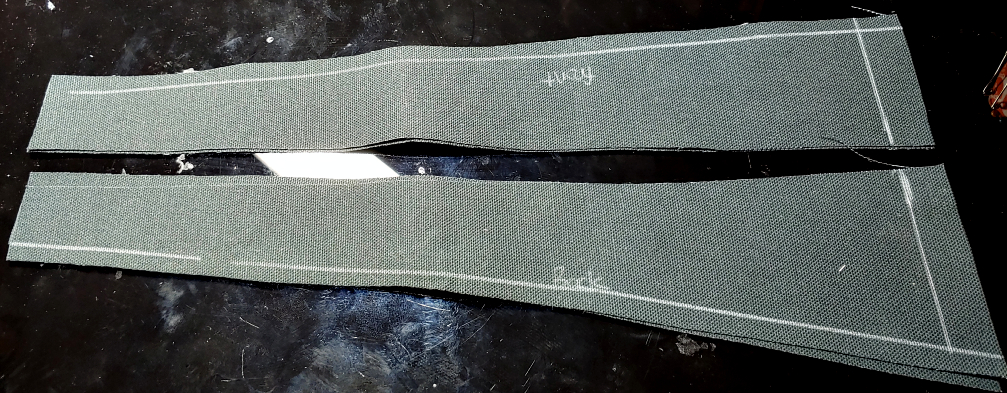 Seam allowances marked in white on black duck canvas fabric. The pattern pieces are labeled front and back