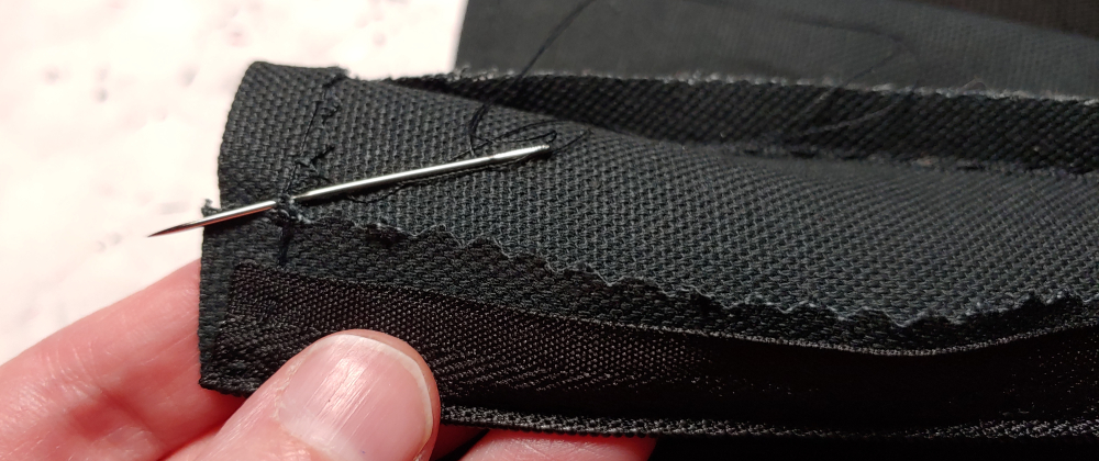 Securing the top of the boot and zipper with a few stitches. The needle is tucked into the stitches as I tie the knot.