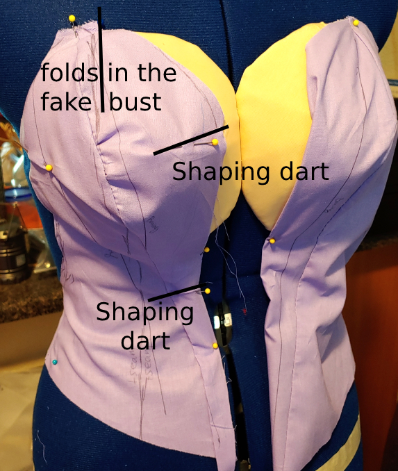 Plunging neckline cut out and shaped around the fake bust. Shaping darts are added to make the corset appear to stick to the bust