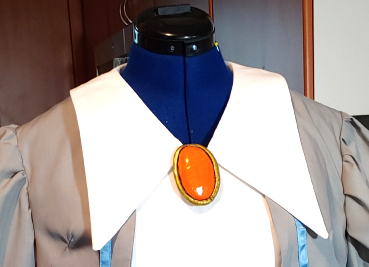 Pumpkin orange foam clay brooch pinned between the two collar pieces