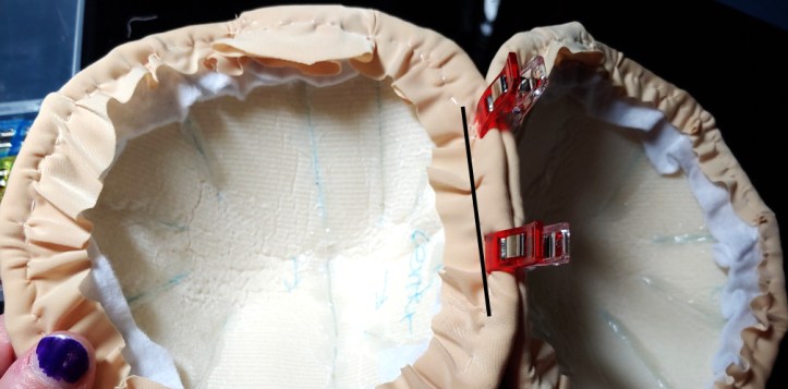 Two tatas clipped together with red clips. The sewing line is marked with a black line.