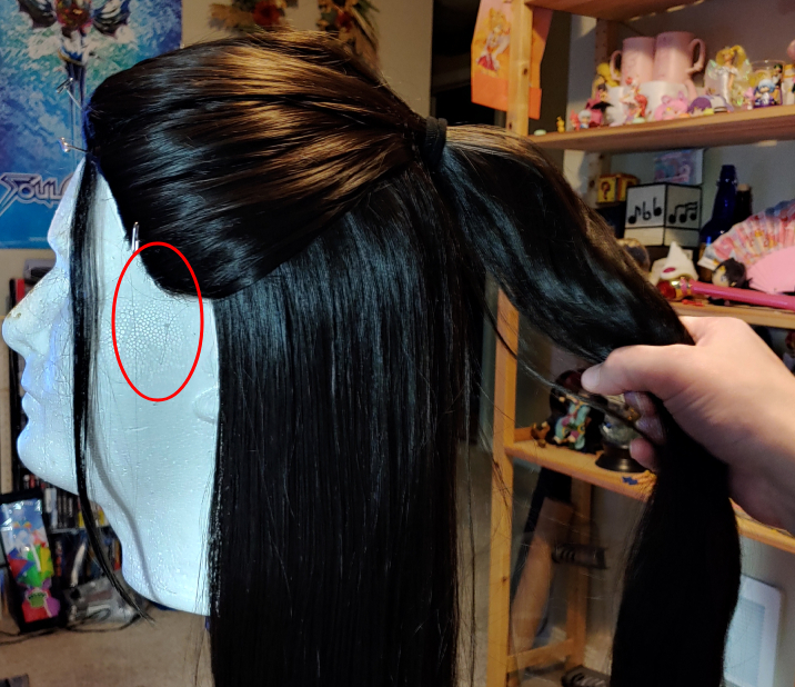 Wig with the lack of sideburns marked in red.