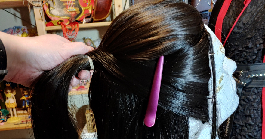 Use clips to stabilize your work as you add the sideburn hair to the ponytail