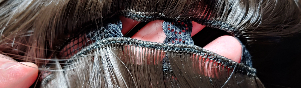 Fibers pulled up to show the row of wefts that are sewn together and then sewn into the wig itself.