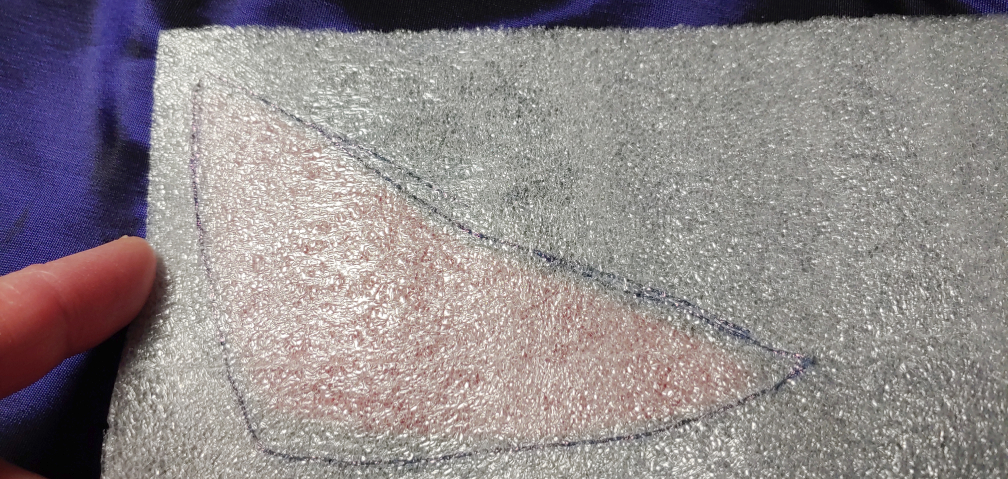 Tracing the cutout in the LED foam. The red color of the eye cutout is slightly visible behind the foam.