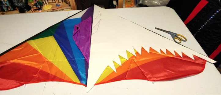 Patterning half the kite. The keel in purple is pushed to the side. Half the kite is covered in poster board pattern paper