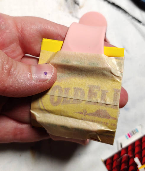 Creating the base by connecting the two halves of the watch band with a piece of food box