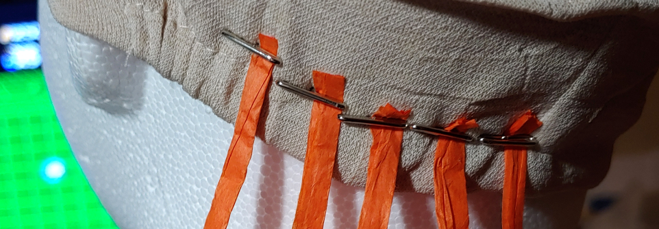 Several orange raffia strands attached with t-pins