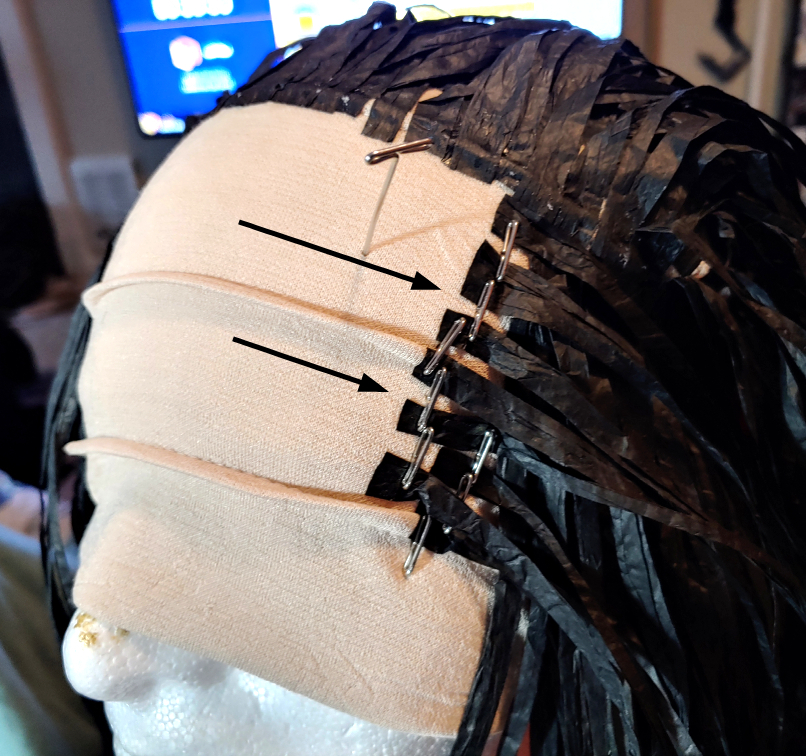 Gluing the first two rows of bang strands. Arrows indicate the direction which the bangs should be glued