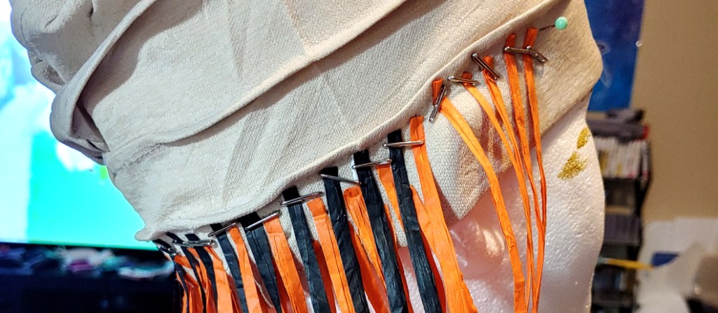 Row 3 glued all the way around the back. Over the ear is orange while around the back of the head is black.