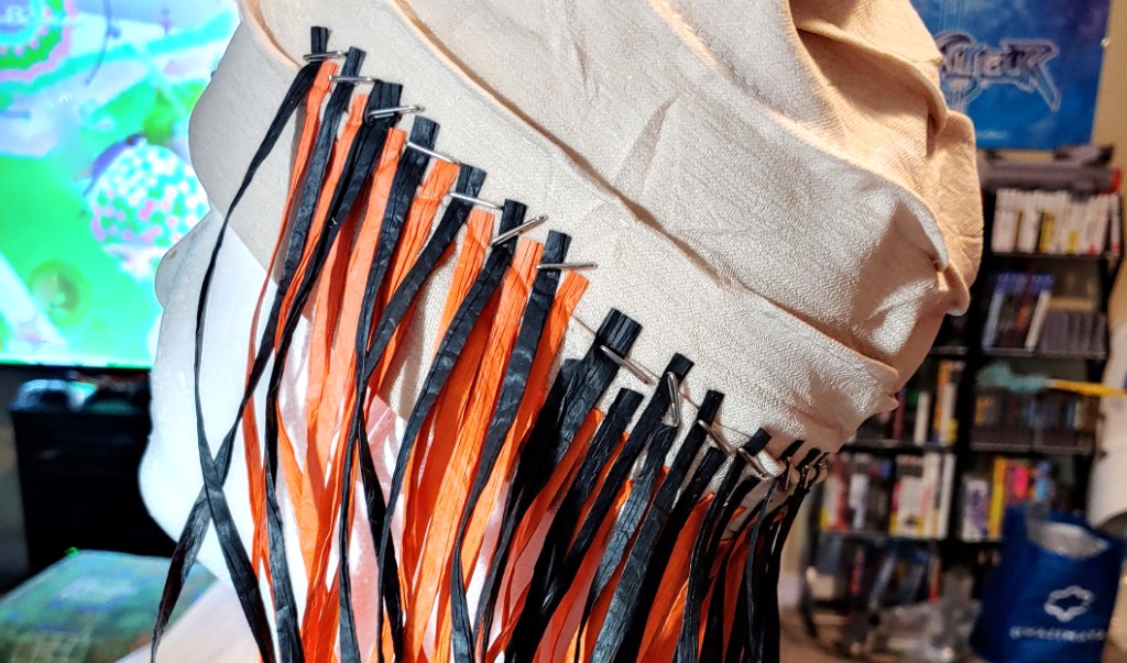 Row 5 begins the single color row. Black strands sit above the orange ear strands and continue around the back of the head.