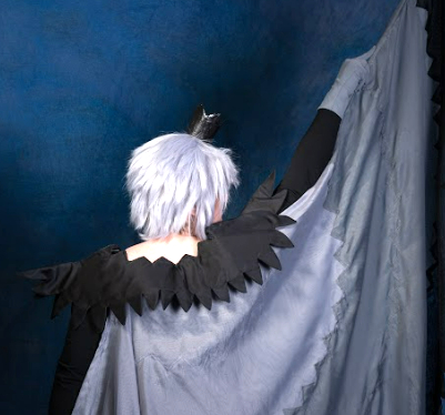 Full cosplay for Raven Mytho, viewed from the back with one half of the Isis wings held up. The shoulders are staying put despite an arm raised up.