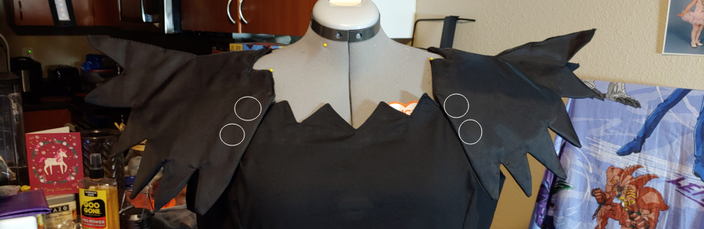 Shoulders attached with snap locations circled in white.