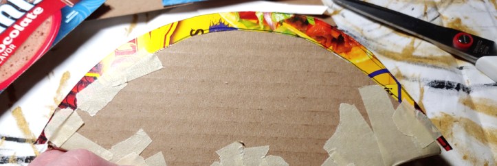 Taping the blade to the axe head. The blade is taped along the sides while taping in the center is in progress.