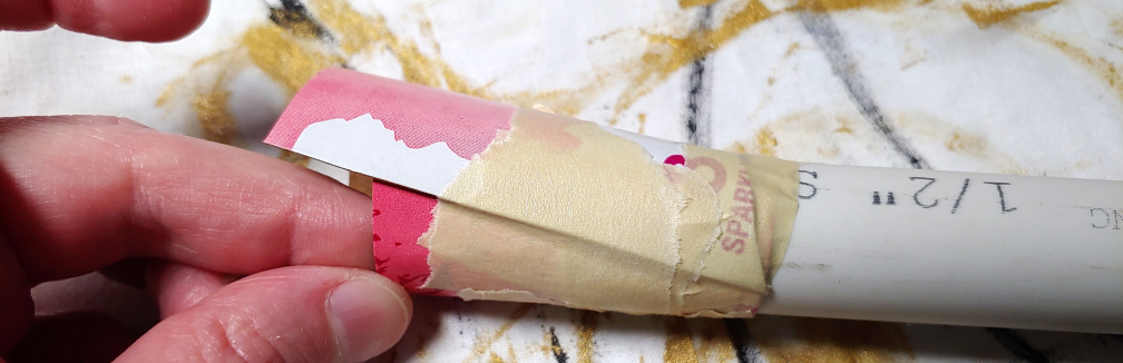 Two pieces taped together. The top piece has a rounded notch cut out of the bottom and the top extends past the previously placed piece