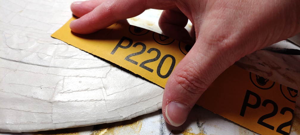 Using 220 grit sandpaper on an axe head