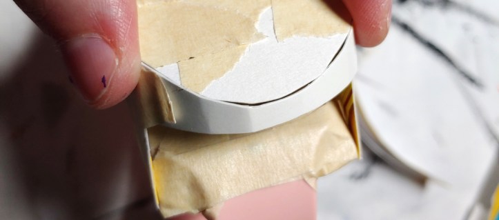 Taping the first strip down on the front face. 