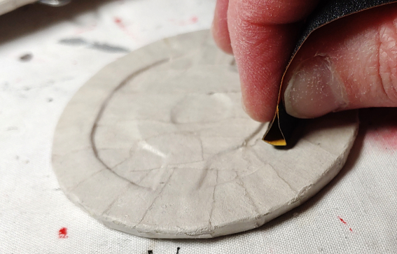 Folded sandpaper is able to get into those tight cutouts. Sandpaper is folded then used like an eraser on a pencil to rub in the tight cutouts.