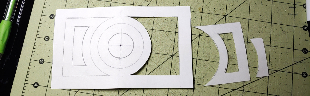 Belt buckle pattern details partially cut out using a box knife. The detail pieces are sitting to the side of the larger pattern.