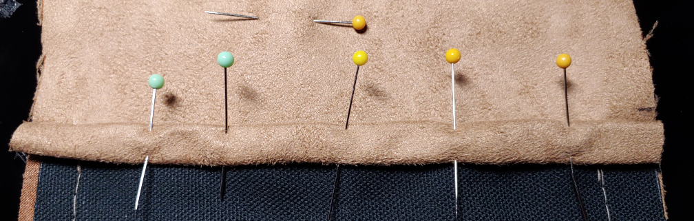 Double-folded edge pinned. The pin at the top is ensuring the two layers don't move while folding